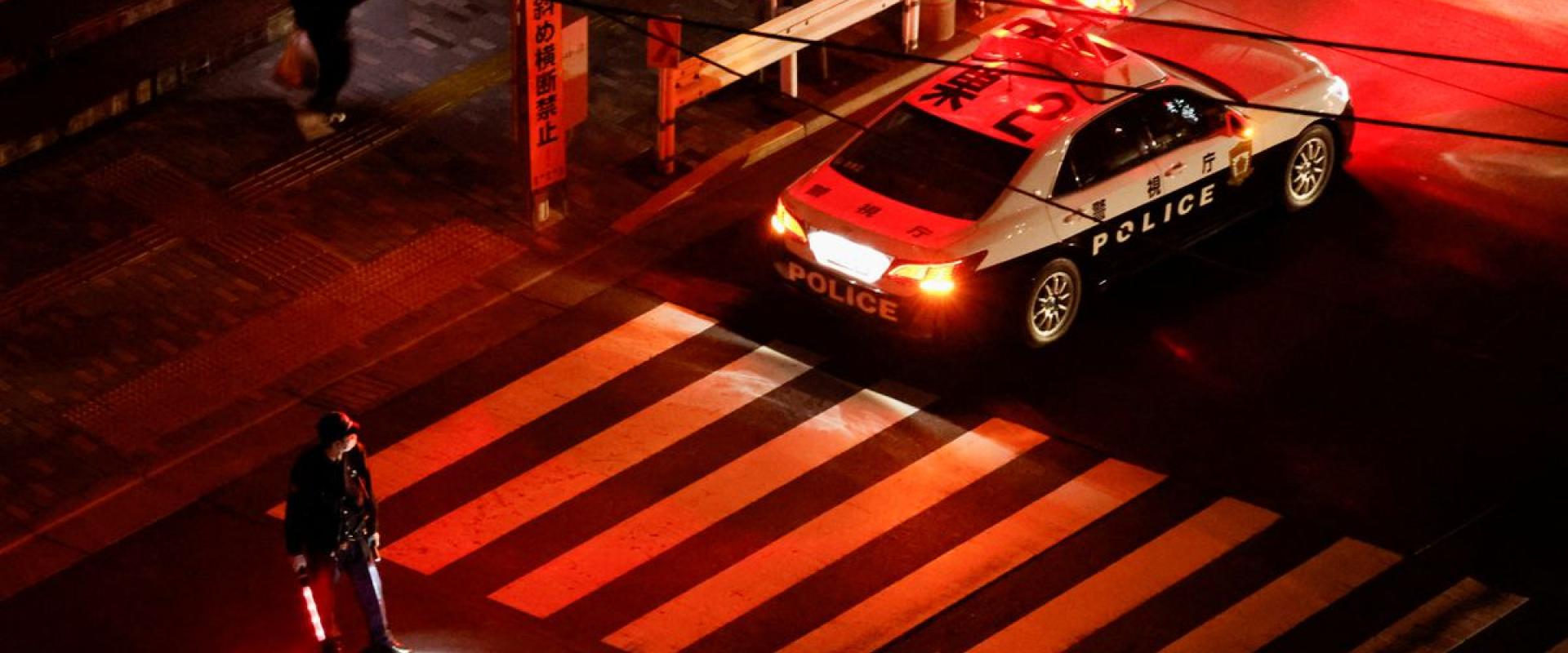 A police officer tries to control traffic on the street during an electric stoppage after an earthquake in Tokyo, Japan March 17, 2022. REUTERS/Issei Kato