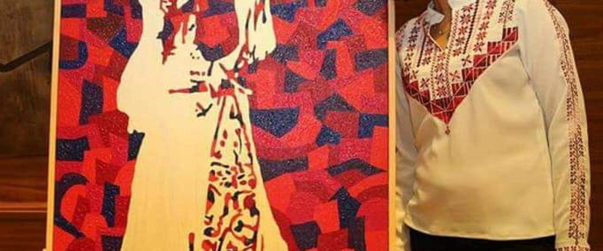 الفنانة نمير قاسم مع لوحتها التي عرضت في الولايات المتحدة وظهرت في صحيفة النيويورك تايمز