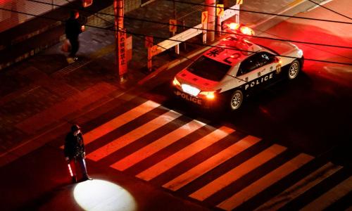 A police officer tries to control traffic on the street during an electric stoppage after an earthquake in Tokyo, Japan March 17, 2022. REUTERS/Issei Kato