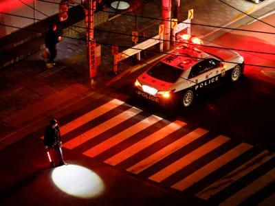 A police officer tries to control traffic on the street during an electric stoppage after an earthquake in Tokyo, Japan March 17, 2022. REUTERS/Issei Kato