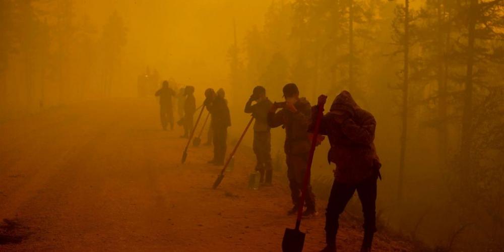 متطوعون يتوقفون أثناء العمل في موقع حريق غابة بالقرب من قرية كيويورلياخ في منطقة غورني أولوس غرب ياكوتسك في روسيا ، 7 أغسطس ، 2021. الصورة نقلا اسوشيتد برس 